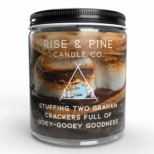 A clear glass jar candle with a black screw-top lid, featuring a front label with toasted marshmallows and the text 'RISE & PINE CANDLE CO.' and 'STUFFING TWO GRAHAM CRACKERS FULL OF OOEEY-GOOEEY GOODNESS.